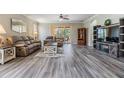 Open-concept living area features gray floors, large sofa, and a view to outdoor seating at 7815 Blue Spring Dr, Land O Lakes, FL 34637