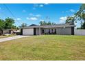 Daytime view of a single-story home featuring a two-car garage and a spacious front yard at 10115 Kenlake Dr, Riverview, FL 33578