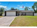 Single-story home with a two-car garage, well-kept lawn, and mature trees at 10115 Kenlake Dr, Riverview, FL 33578