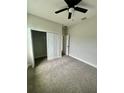 A cozy bedroom with carpeted floor and closet with sliding doors and fan at 12219 Bacchus Rd, Port Charlotte, FL 33981