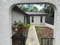 Charming facade featuring an arched entryway that leads to the front door, with fresh mulch and green grass at 1309 Malone Ave, Spring Hill, FL 34606