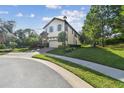 Charming two-story home featuring manicured landscaping and a paved driveway at 1341 Marinella Dr, Palm Harbor, FL 34684