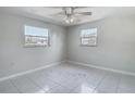 Bedroom featuring tile floors and two windows at 1408 Maybury Dr, Holiday, FL 34691