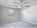 Bedroom featuring tile floors, a ceiling fan, and a window at 1408 Maybury Dr, Holiday, FL 34691