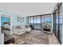 Cozy living room with ocean views, comfortable seating, and a glimpse into the adjacent bedroom at 15400 Gulf Blvd # 202, Madeira Beach, FL 33708