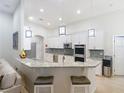 Bright, modern kitchen with stainless steel appliances, granite countertops, and breakfast bar seating at 15625 Hawks Crest Loop, Odessa, FL 33556