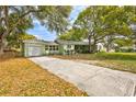View of the front exterior showing the garage and long driveway to the home at 1984 Trotter Rd, Largo, FL 33774