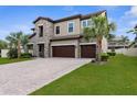 Beautiful exterior elevation with a three-car garage, paver driveway, and well maintained lawn and landscaping at 21878 Amelia Rose Way, Land O Lakes, FL 34637