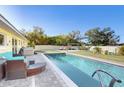 Backyard oasis with a stunning pool, lush landscaping, and comfortable patio furniture at 22396 Nyack Ave, Port Charlotte, FL 33952