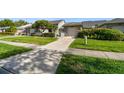 Charming home exterior with a well-manicured lawn, tidy landscaping, and a convenient attached garage at 232 Hunter Ct, Palm Harbor, FL 34684