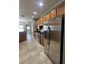 Well-lit kitchen featuring stainless steel appliances, wooden cabinetry, and tiled flooring at 2603 Valencia Grove Dr, Valrico, FL 33596