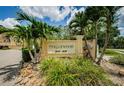 Community sign for Tanglewood with lush landscaping, rocks and Palm trees at 2674 Tanglewood Trl, Palm Harbor, FL 34685
