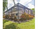 Backyard showcasing a screened-in patio with lush landscaping and an inviting outdoor space at 309 Dakota Hill Dr, Seffner, FL 33584