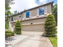 Stunning two-story home featuring an attached two-car garage, complemented by beautifully trimmed trees and shrubs at 309 Dakota Hill Dr, Seffner, FL 33584