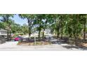 Gated single Gathering home with large trees, lush landscaping, and a red sports car at 3114 Little Rd, Valrico, FL 33596