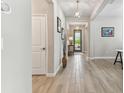 Inviting hallway with light wood-look flooring and modern light fixtures at 31637 Cannon Rush Dr, San Antonio, FL 33576