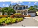 Elegant two-story home with lush landscaping, brick paver driveway, and a welcoming front porch with white columns at 3311 Home Ct, Tampa, FL 33611
