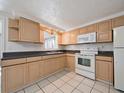 Cozy kitchen with light wood cabinets, white appliances, and ample counter space at 3338 Hoover Dr, Holiday, FL 34691