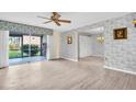 Living room with light wood flooring, patterned wallpaper, and sliding glass doors to outdoor space at 3815 35Th S Way # 102, St Petersburg, FL 33711