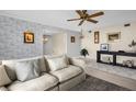 A cozy living room offers stylish wallpaper, wood floors, modern furniture, and a ceiling fan at 3815 35Th S Way # 102, St Petersburg, FL 33711