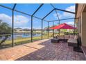 Relaxing screened patio with brick pavers, overlooking a tranquil pond view, and comfortable seating at 4145 Shrewbury Pl, Land O Lakes, FL 34638