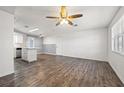 Open floor plan featuring hardwood flooring, white walls, ceiling fan and kitchen island at 4220 Oakfield Ave, Holiday, FL 34691