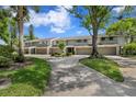 View of the front exteriors of the townhomes with a driveway and sidewalks at 4240 Golf Club Ln, Tampa, FL 33618