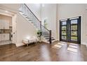 Bright foyer with hardwood floors, staircase, bench and dark modern double door at 481 W Davis Blvd, Tampa, FL 33606