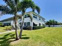 Condominium building with tropical landscaping and a well-manicured lawn showcasing a serene outdoor environment at 5227 81St Lane N # 26, St Petersburg, FL 33709