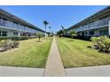 Condominium complex with well-kept lawn and tropical landscaping, showcasing a serene and inviting community atmosphere at 5227 81St Lane N # 26, St Petersburg, FL 33709
