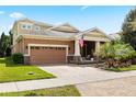 Inviting home featuring a two-car garage, brick paved driveway, mature landscaping, and a cozy front porch at 5310 Sanderling Ridge Dr, Lithia, FL 33547