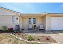 Inviting front porch with seating area and decorative potted plants, adding charm to the entrance at 6416 Lomand Ave, New Port Richey, FL 34653
