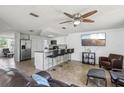 Open-concept living room featuring a breakfast bar, stainless steel appliances, and cozy seating at 6416 Lomand Ave, New Port Richey, FL 34653