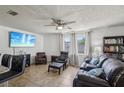 Comfortable living room with large windows, plush seating, and built-in bookcase at 6416 Lomand Ave, New Port Richey, FL 34653