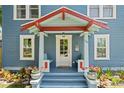 Inviting front porch with a colorful entrance, seating, and potted plants at 701 14Th N St, St Petersburg, FL 33705