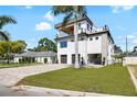 Contemporary three-story home with private balconies and a well-maintained front lawn at 706 S Davis Blvd, Tampa, FL 33606