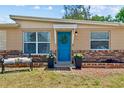 Inviting front entrance with a bright blue door, decorative wreath, and charming brick accents at 8184 Rose Ter, Seminole, FL 33777