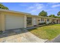 Inviting one-story home with a manicured lawn, garage, and charming curb appeal at 834 Cambridge Ct, Dunedin, FL 34698