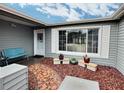 Covered entryway featuring tiled path, white door, large picture window and bench at 8413 Moulton Dr, Port Richey, FL 34668