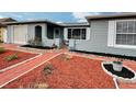 Single-story home with attached garage, decorative mulch landscaping and arched entry at 8413 Moulton Dr, Port Richey, FL 34668