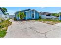 Charming blue home with well-maintained landscaping, complemented by a spacious driveway for easy parking at 9206 Wood Lake Blvd, Tampa, FL 33615