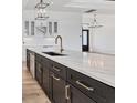 Modern kitchen featuring a large marble island with dark cabinets and gold hardware at 9412 President Cir, Port Charlotte, FL 33981