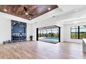 Bright living room featuring a wood ceiling, unique fireplace, and doors that lead to the pool at 9412 President Cir, Port Charlotte, FL 33981