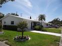 Well-maintained single-story home with a green lawn and mature landscaping on a sunny day at 9825 41St N St, Pinellas Park, FL 33782