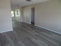 Spacious living room with modern gray wood flooring and neutral walls, bathed in natural light at 9825 41St N St, Pinellas Park, FL 33782