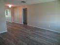 Open living room with wood flooring, neutral walls, and a glimpse into adjoining rooms at 9825 41St N St, Pinellas Park, FL 33782