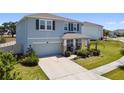 Charming two-story home featuring a manicured lawn, elegant stone accents, and an attached two-car garage at 10749 Tally Fawn Loop, San Antonio, FL 33576