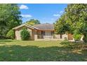 Landscaped single-story home featuring a well-maintained lawn and decorative iron fencing at 1379 Matthew Ave, Spring Hill, FL 34609
