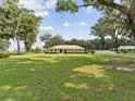 Beautiful single-story home with a well-maintained lawn and mature trees at 1414 Stephens Oak Ct, Plant City, FL 33567