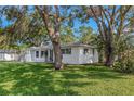 Side view of a charming single-story home with mature trees shading the lawn at 1432 S Keene Rd, Clearwater, FL 33756